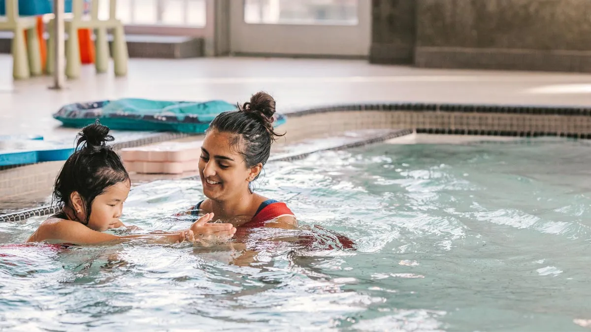A child taking a swim lesson with a YMCA instructor at the Bettie Allard YMCA in Coquitlam