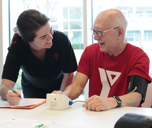 A participant of the YMCA Healthy Heart program interacting with a staff member